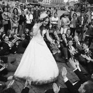 wedding photography in Rome: a group of young students sings for a bride in front of the Colosseo in Rome, Italy. Fotografia di matrimonio a Roma, un gruppo universitario americano canta sdraiato per una sposa nella piazza del Colosseo.